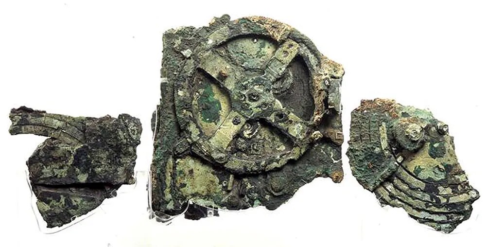 Corroded bronze fragments of the Antikythera Mechanism showing interlocking gears and astronomical scales.